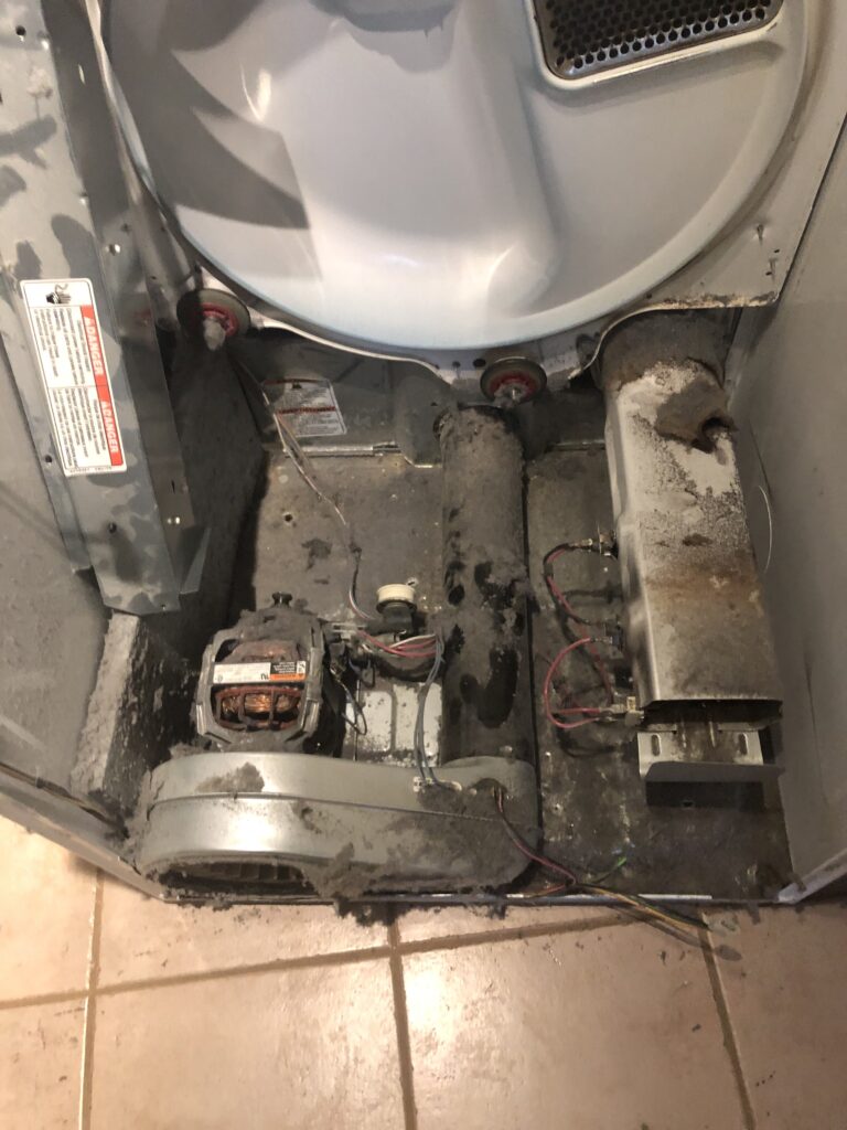 A dryer with burnt lint inside where the dryer was smoking and almost started a house fire.